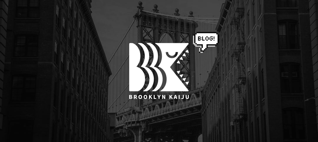The Brooklyn Kaiju logo with a pixel speech bubble and the words "blog!" in the speech bubble.  The image is overlayed a greyscale image of the Brooklyn bridge.