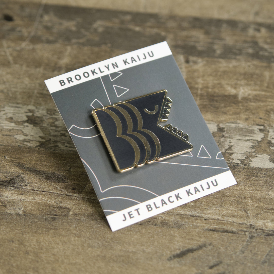 Black and gold hard enamel Brooklyn Kaiju logo pin