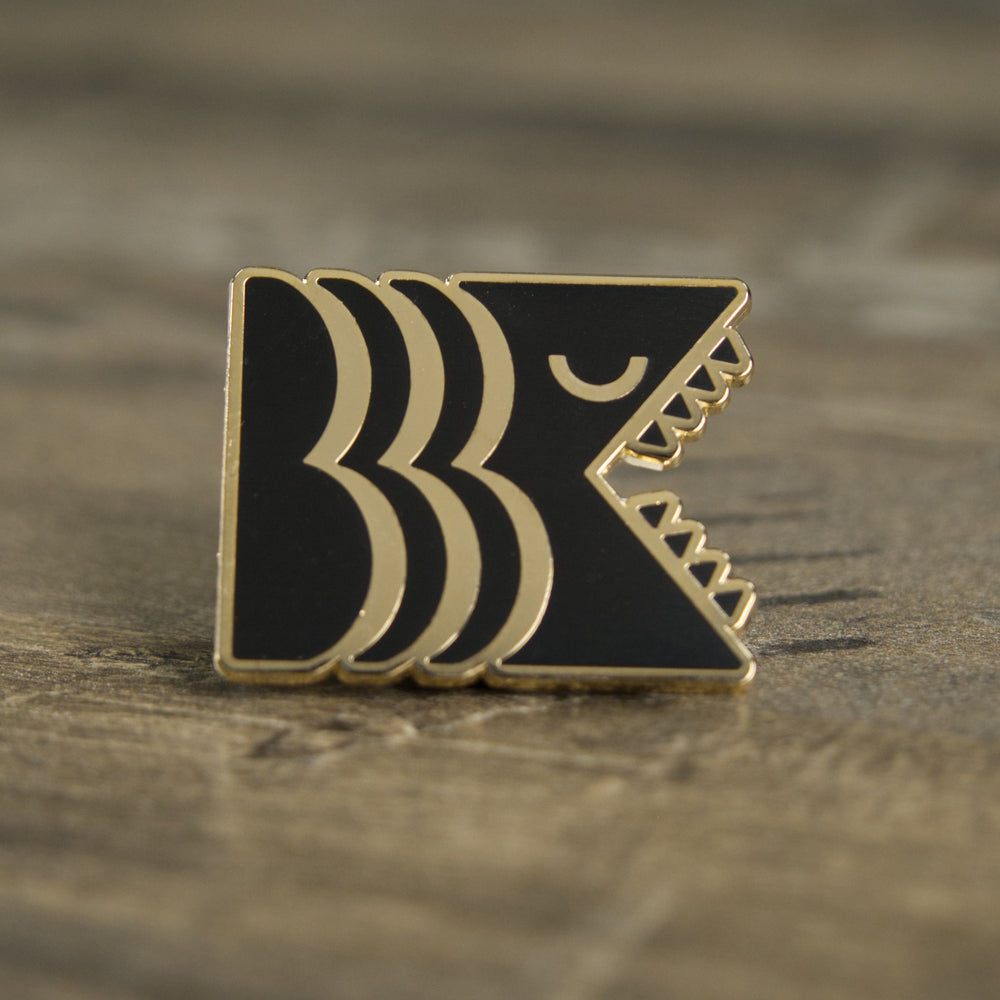 Black and gold hard enamel Brooklyn Kaiju logo pin