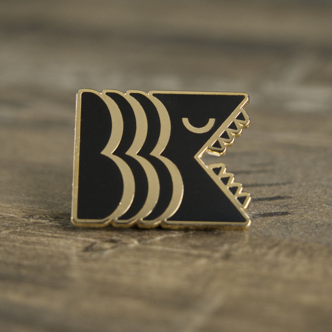 Black and gold hard enamel Brooklyn Kaiju logo pin