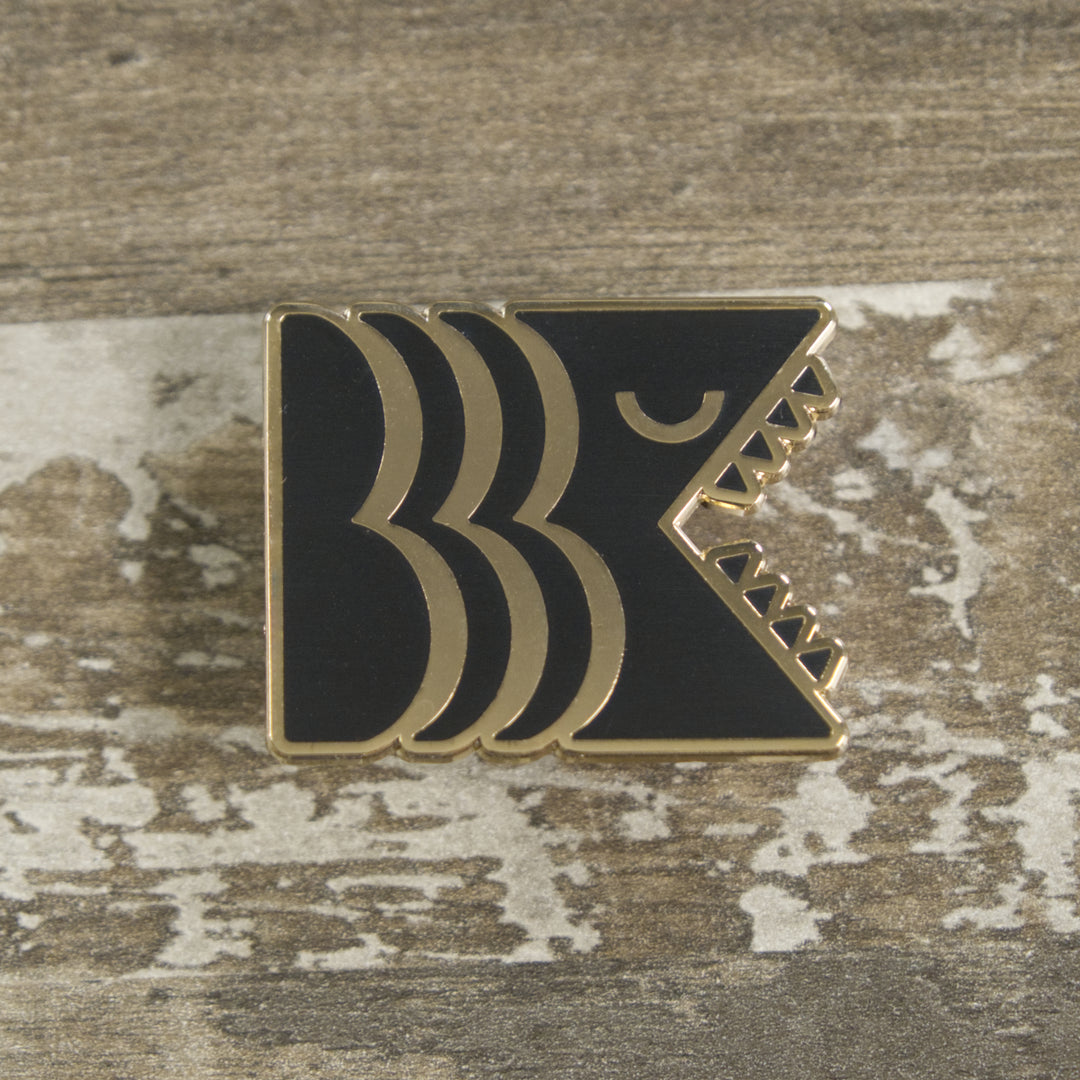 Black and gold hard enamel Brooklyn Kaiju logo pin