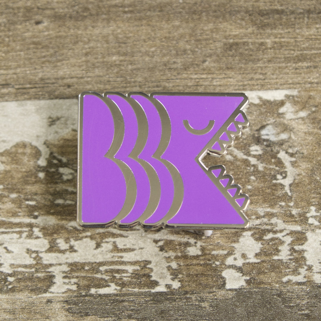 Brooklyn Kiaiju Purple Logo Pin laying flat on table